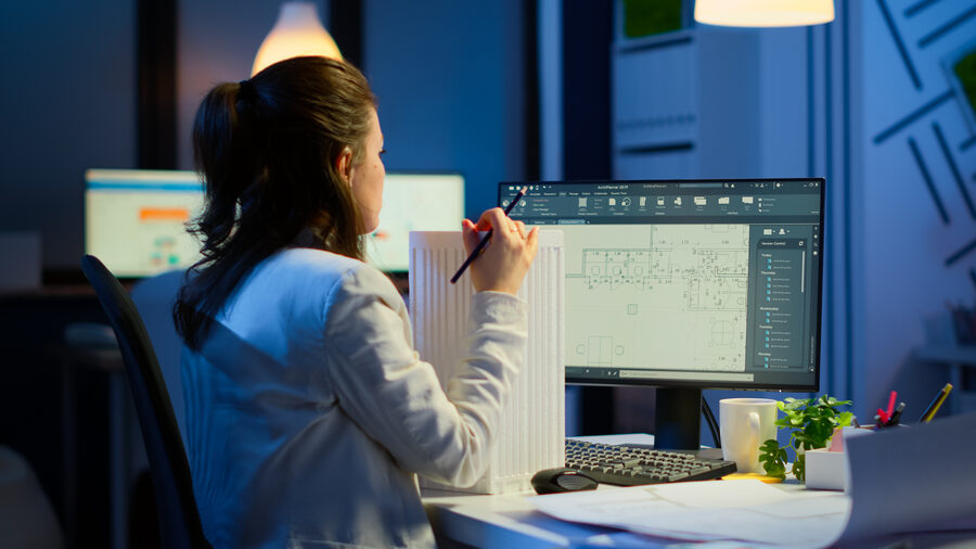 Architect working at a workstation reviewing large design files