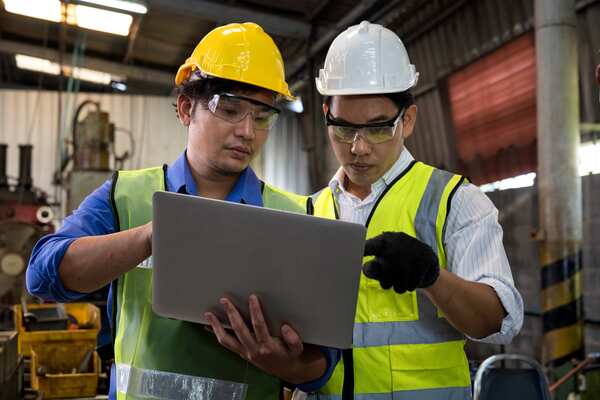 Manufacturing engineers reviewing data on factory floor